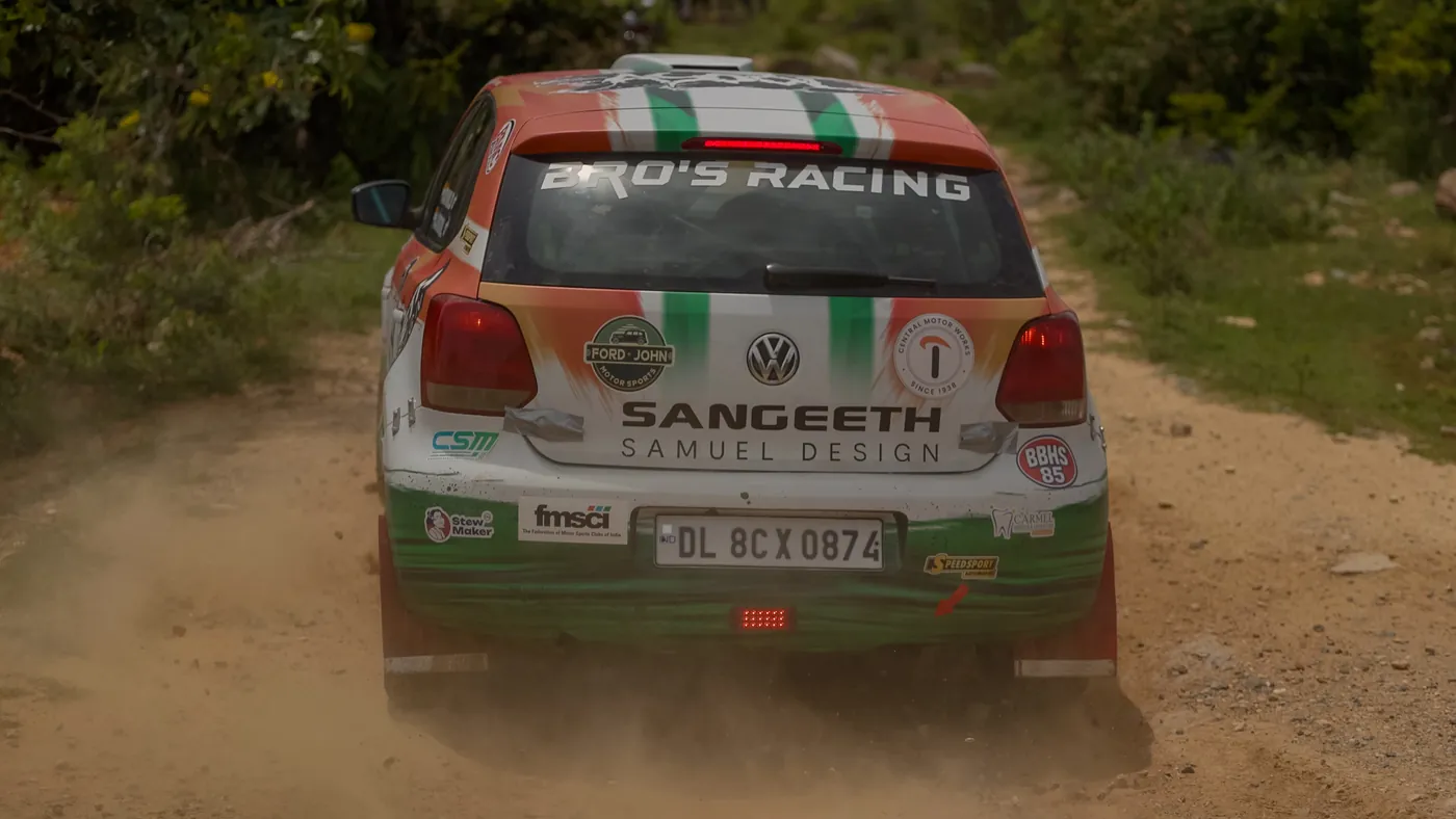 Rally car powering through a dust cloud at Dakshin Dare