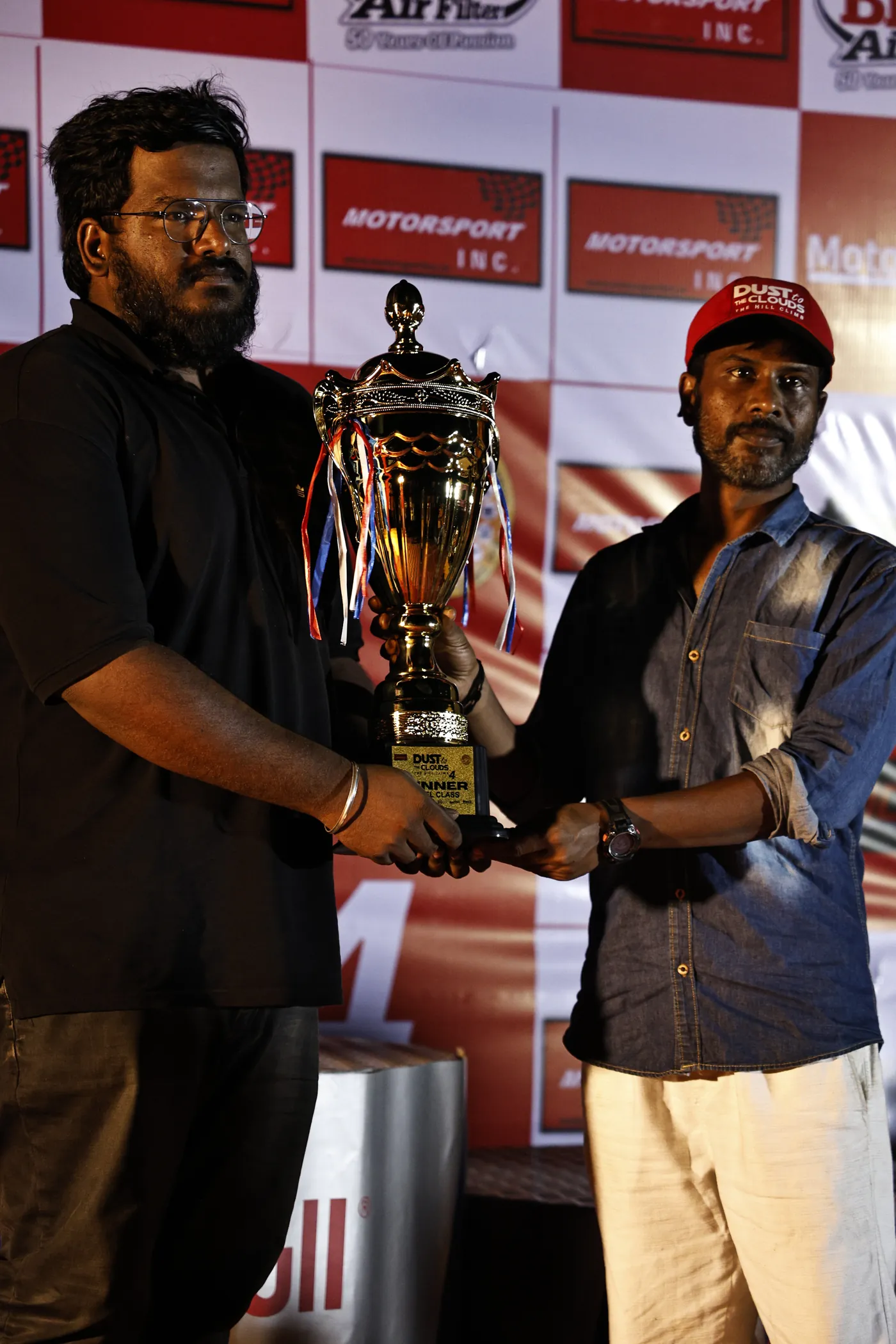 Class winner receiving his trophy under the lights at Dust to the Clouds 4