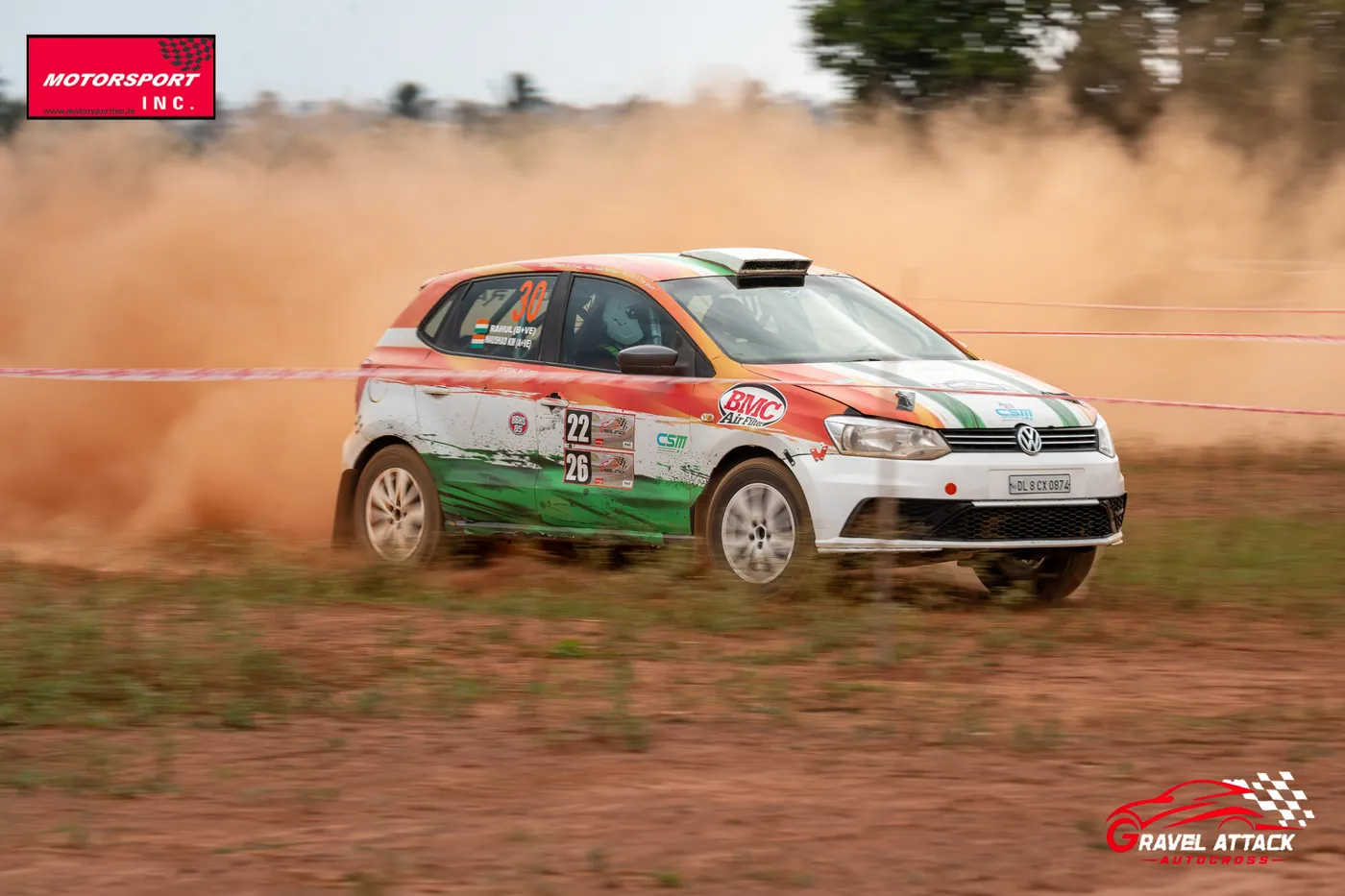Rally car sliding through a dust-filled corner at Gravel Attack