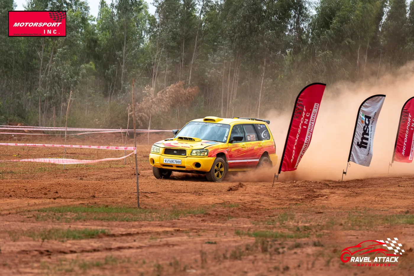 Car kicking up orange dust past the marker flags at Gravel Attack